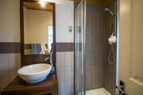 y baño con lavabo y ducha. en Modern 4 Berth Lodge With Decking At Manor Park In Hunstanton Ref 23024w, en Hunstanton