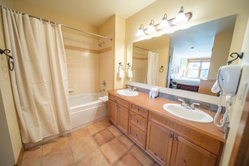 La salle de bains est pourvue de 2 lavabos, d'une baignoire et d'un miroir. dans l'établissement Springs 8870, à Keystone