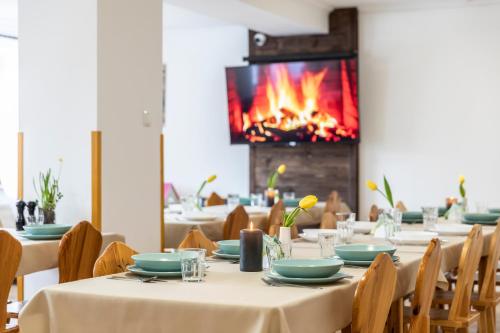 een eetkamer met tafels en een open haard bij Pokoje Gościnne Góraleczka Kościelisko in Kościelisko
