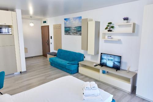 Una sala de estar con un sofá azul y un televisor. en Studio Melody Nord 10, en Năvodari