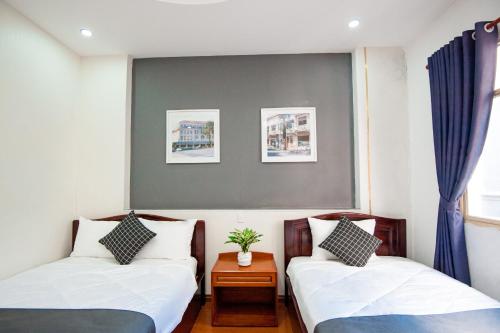 a room with two beds and a table and a window at Saigon Hub Hostel in Ho Chi Minh City