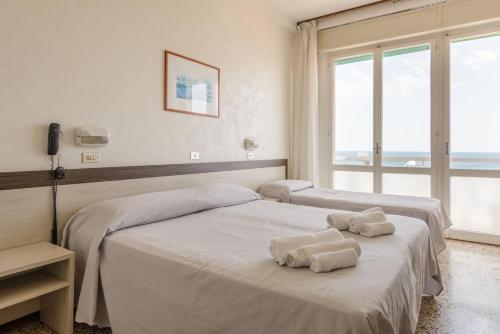 a hotel room with two beds with towels on them at Hotel Europa in Gabicce Mare
