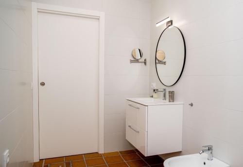 Baño blanco con lavabo y espejo en Apartamentos Casa Tuli B, ALJARAQUE en Aljaraque