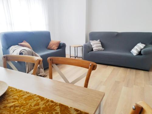 una sala de estar con 2 sofás azules y una mesa. en ESPECIAL HOME apartamento reformado 6 huéspedes en Avilés
