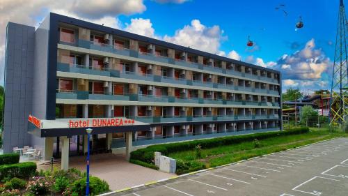 ein Hotel vor einem Parkplatz in der Unterkunft HOTEL DUNĂREA in Mamaia