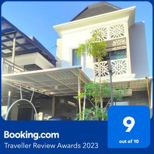 a house with awning in front of it at Family Villa Syariah C-37 Batu in Batu