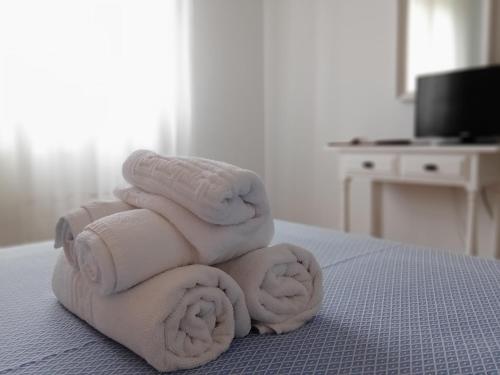 a pile of towels stacked on top of a bed at Hotel Con D´Arbon in A Lanzada