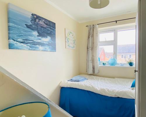 a small bedroom with a bed and a window at A single-bed room with a guest lounge in Cheltenham