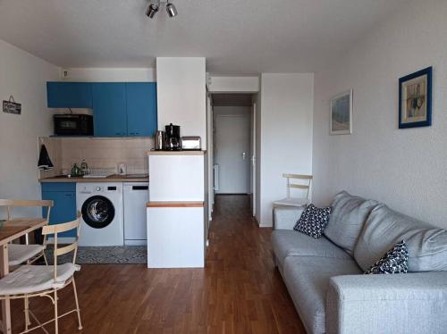 a living room with a couch and a kitchen at Le Voilier - 200m du port - Calme in La Trinité-sur-Mer