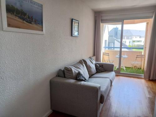 a living room with a couch and a large window at Le Voilier - 200m du port - Calme in La Trinité-sur-Mer