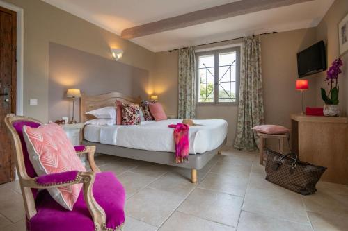 a bedroom with a large bed and a window at Hotel Les Messugues in Saint Paul de Vence