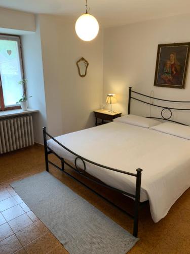 a bedroom with a large white bed in a room at Bed & Breakfast Casa Marinella in Lenna