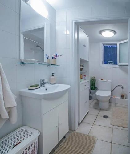 a white bathroom with a sink and a toilet at Corfu Stinados Apartment in Ermones