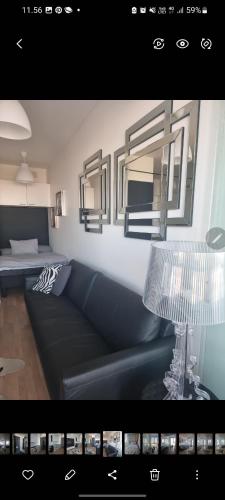 a living room with a couch and two mirrors at Tampere City studio Areena in Tampere