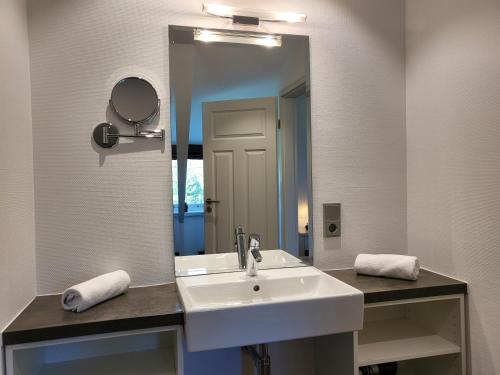 een badkamer met een wastafel en een grote spiegel bij Ferienwohnung Mühlenhof 7 in Sankt Peter-Ording