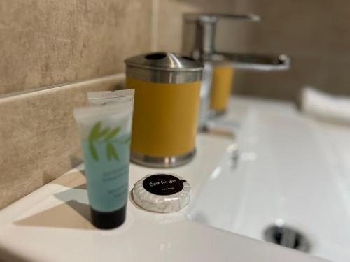 a bathroom sink with a cup and a drink at Tumbleweed Cottage in Newark-on-Trent