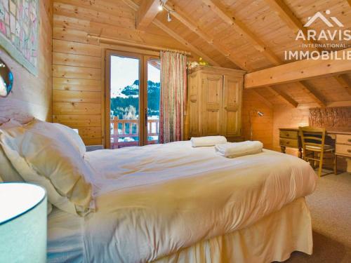 een slaapkamer met een groot bed in een hut bij Chalet Le Grand-Bornand, 7 pièces, 12 personnes - FR-1-391-30 in Le Grand-Bornand