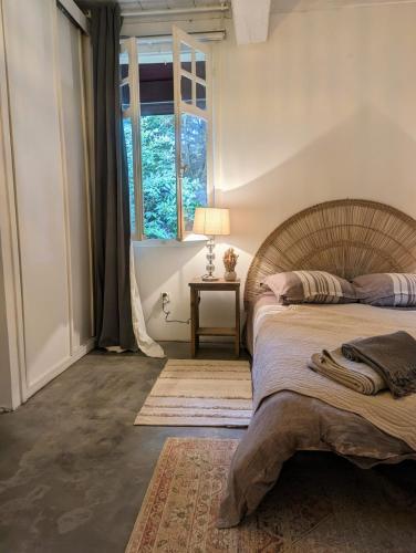 une chambre avec un grand lit et une fenêtre dans l'établissement Maison Pimoli : Chambre Garance, à Soustons