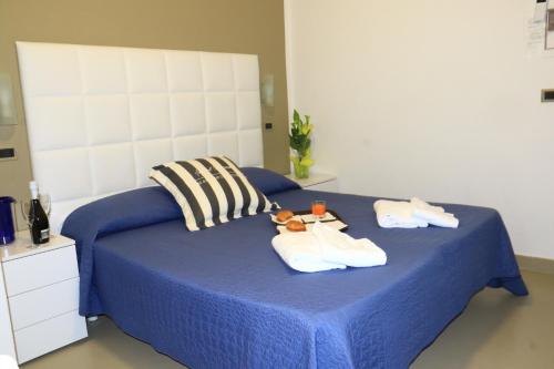 een blauw bed met handdoeken en teddyberen erop bij Hotel Diamante in Cattolica