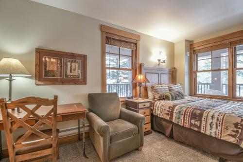1 dormitorio con cama, escritorio y silla en Springs 8822, en Keystone