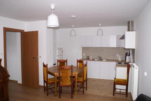 a kitchen and dining room with a table and chairs at Willa Moja Gawra in Lądek-Zdrój