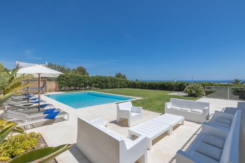 Villa con piscina y sillas azules en Villa con vistas al mar, en Sant Jordi