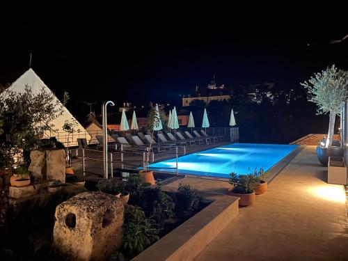 a swimming pool at night with chairs and plants at Resort Valtberg - Depandance in Valtice