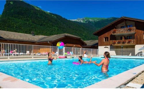 um grupo de pessoas brincando em uma piscina em Samoëns Appartement T3 RDC 6 personnes, piscines, sauna, salle de détente sports em Samoëns