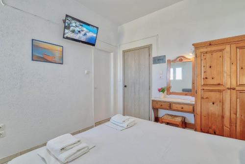a white bedroom with a bed and a sink at Pavlos Place in Antiparos Town