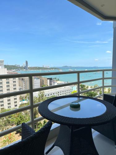 a balcony with a table and chairs and the ocean at View Talay6 by Blue Ocean Suite in Pattaya Central