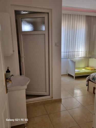 a bathroom with a door leading to a bedroom at RAINFORT APART salda gölü kiralık apart in Yeşilova