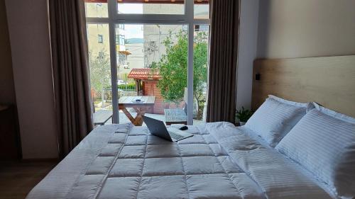 a bedroom with a bed with a laptop on it at Elvish Garden Boutique B&B in Berat
