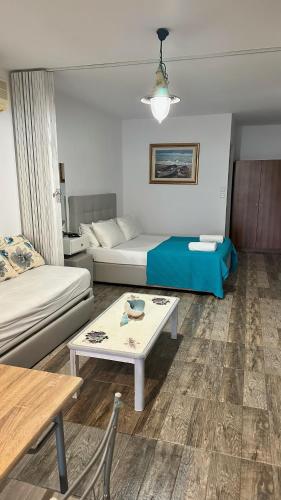 un soggiorno con divano, letto e tavolo di LUUMA APARTMENT'S a Thymonia Beach