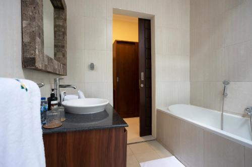 ein Badezimmer mit Badewanne und Waschbecken in der Unterkunft Villa Katara in Seminyak