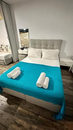 a bedroom with a bed with two white slippers on it at LUUMA APARTMENT'S in Thymonia Beach