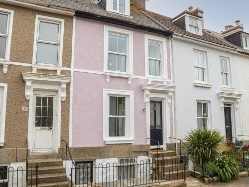 a pink and white house with white windows at The Lookout in Penzance