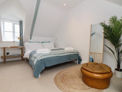 1 dormitorio con cama con reposapiés y taburete en The Lookout, en Penzance