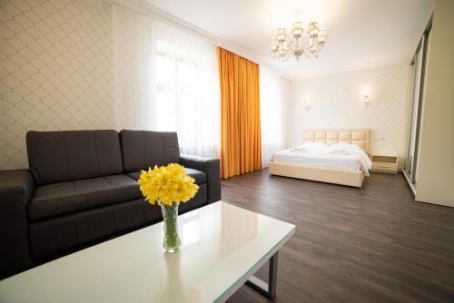 a living room with a couch and a table with yellow flowers at ASAO-Apartments walking center zone in Lviv