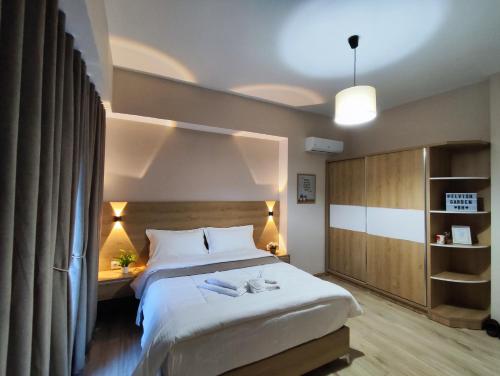 ein Schlafzimmer mit einem großen weißen Bett in einem Zimmer in der Unterkunft Elvish Garden Boutique B&B in Berat