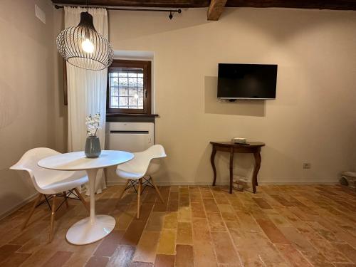 een eetkamer met een tafel en stoelen en een tv bij Borgo Lizori Country House in Campello sul Clitunno