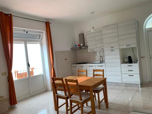 - une cuisine avec une table et des chaises en bois dans l'établissement Casa Colomba Sant'Angelo, à Ischia