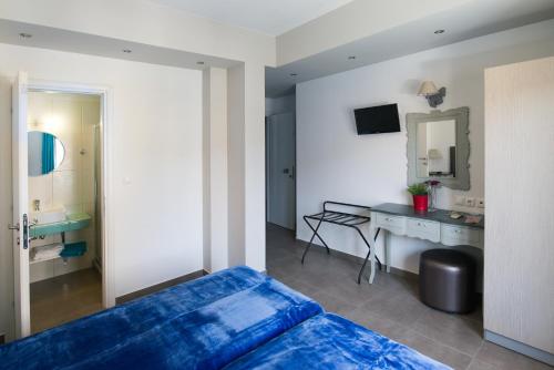 1 dormitorio con cama, escritorio y espejo en Emmeleia Accommodation by Maria Riga, en Ouranoupoli