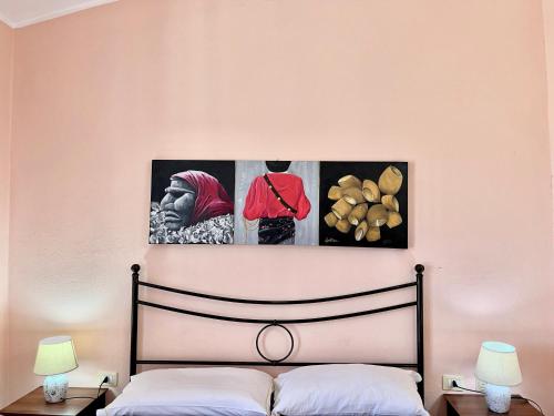 - une chambre avec un lit et deux photos sur le mur dans l'établissement Agricantus 2000, à Capoterra