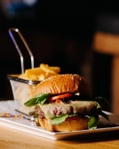 a sandwich on a plate with a container of fries at Le Vieux Valais in Ovronnaz