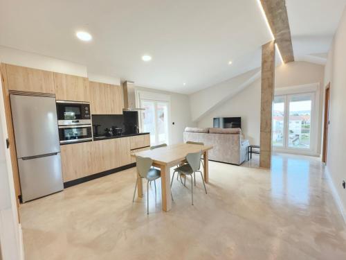 a kitchen and dining room with a table and chairs at Apartamentos Avenida Areas in Sanxenxo