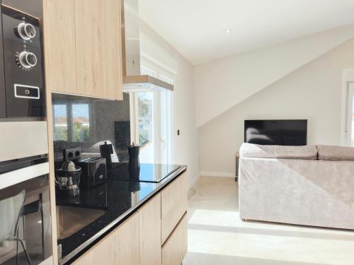 a kitchen with black counter tops and a stove top oven at Apartamentos Avenida Areas in Sanxenxo