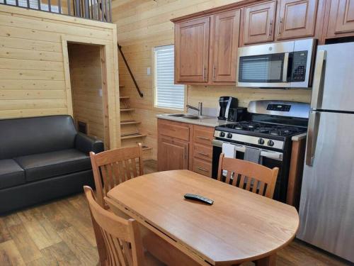 a small kitchen with a table and a couch in a tiny house at 080 Tiny Home nr Grand Canyon South Rim Sleeps 8 in Valle