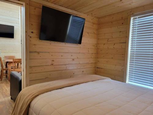 a bedroom with a bed and a tv on a wall at 080 Tiny Home nr Grand Canyon South Rim Sleeps 8 in Valle