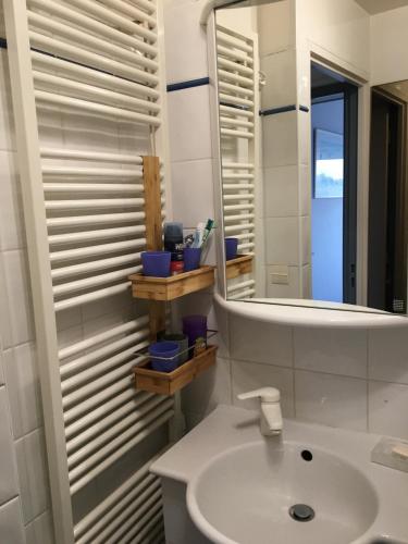 une salle de bain blanche avec un lavabo et un miroir dans l'établissement Le Touquet magnifique appartement 3 chambres vue sur mer, à Le Touquet-Paris-Plage