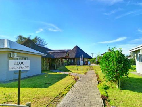 a sign in front of a house with aigil restaurant at Tlou Safari Lodge in Kasane